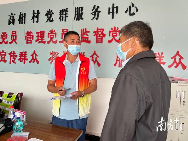正在為群眾辦事的沈家江（左）。